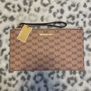 This monogram Michael Kors wristlet in pink is beautiful! BRAND NEW WITH TAGS!